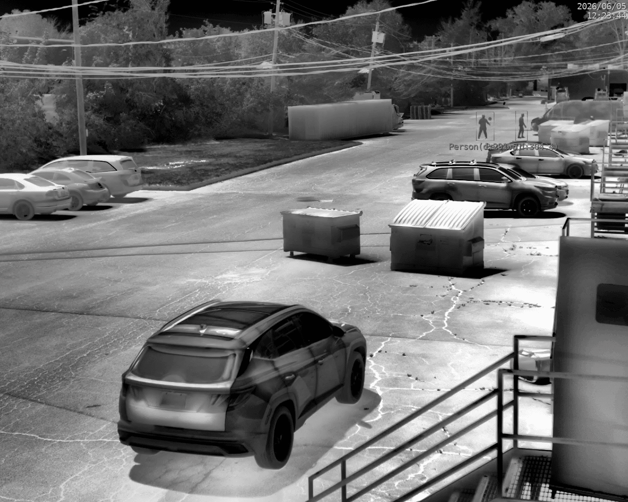 SightLogix thermal view showing people detection on two pedestrians near parked cars